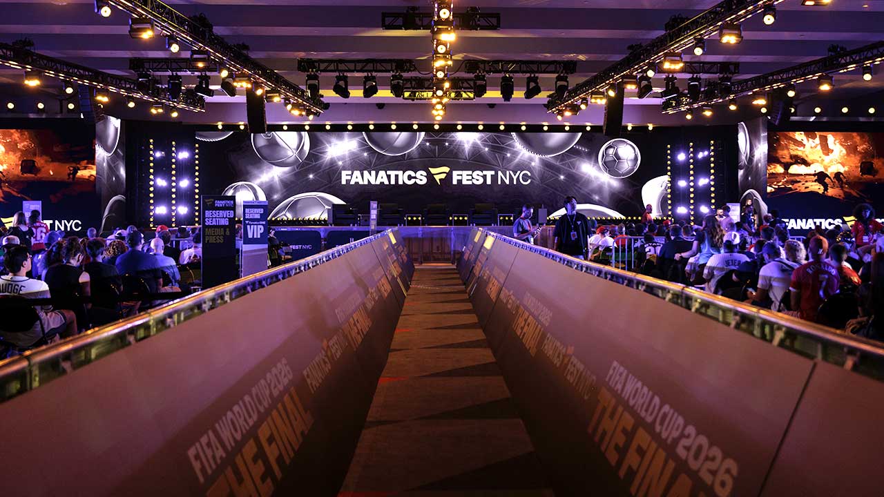 Image looking down the center corridor and onto a big stage with screens and lights along the way 